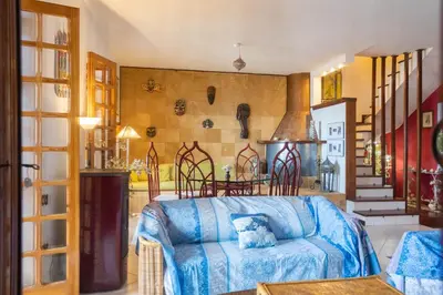 a living room with a blue couch and a table at Villa nel verde sul mare, Mondello, Palermo in Palermo