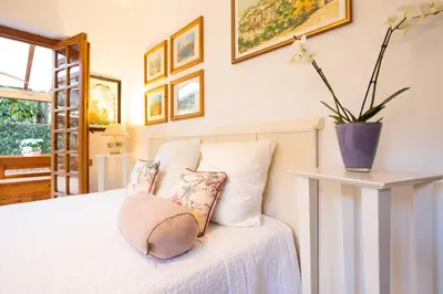a bedroom with a white bed with pillows at Villa nel verde sul mare, Mondello, Palermo in Palermo