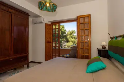 a bedroom with a bed and a sliding glass door at Villa nel verde sul mare, Mondello, Palermo in Palermo