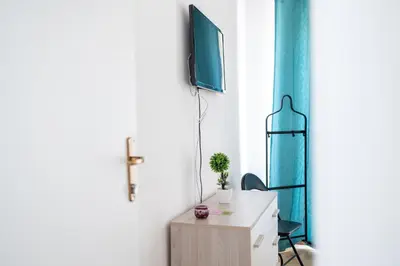 a room with a desk and a tv on a wall at Zangara Flat in Cinisi