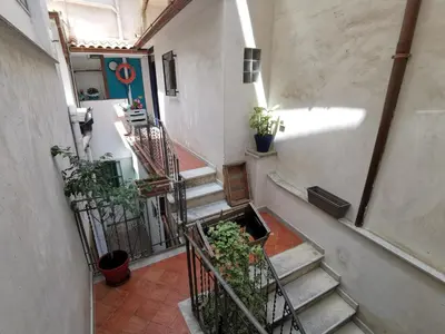 an empty hallway with stairs and potted plants at CasuzzaMia in Palermo