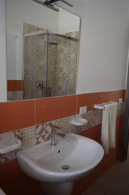 a bathroom with a white sink and a mirror at Acqua Chiara Appartamenti in San Vito lo Capo