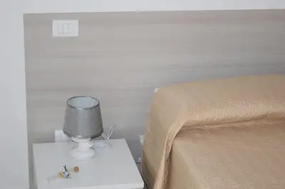 a bedroom with a bed and a table with a lamp at Acqua Chiara Appartamenti in San Vito lo Capo