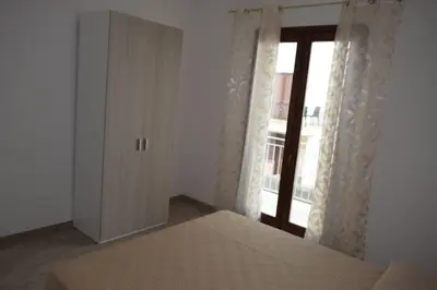a bedroom with a bed and a large window at Acqua Chiara Appartamenti in San Vito lo Capo