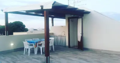 a patio with a table and chairs on a roof at Acqua Chiara Appartamenti in San Vito lo Capo