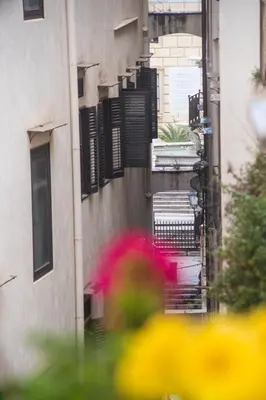 an alley with black shutters on a building at Casa Annuccia ai Quattro Canti di Città in Palermo