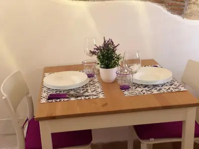 a table with plates and glasses and a plant on it at La casa del Cedro in Palermo