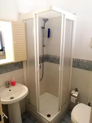 a bedroom with a bed and a table and a window at VENTO di MARE in Palermo