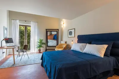 a bedroom with a blue bed and a desk and a mirror at Palermo Magic House in Palermo