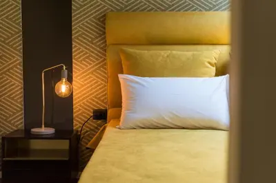 a bedroom with a bed with a white pillow and a lamp at Palermo Magic House in Palermo