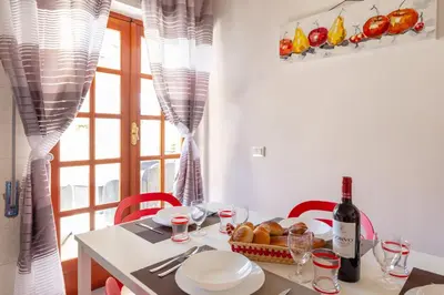 a table with a bottle of wine and a basket of bread at Residenza del Duca - Casteldaccia 2 camere in Casteldaccia
