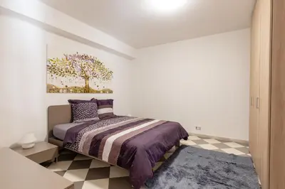 a bedroom with a bed and a painting on the wall at Residenza del Duca - Casteldaccia 2 camere in Casteldaccia
