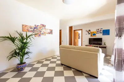 a living room with a couch and a plant at Residenza del Duca - Casteldaccia 2 camere in Casteldaccia