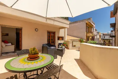 a patio with a table and chairs and an umbrella at Residenza del Duca - Casteldaccia 2 camere in Casteldaccia