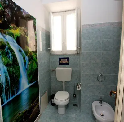 a bathroom with a toilet and a window and a sink at GiaChi friendly rooms alla Stazione in Palermo