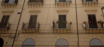 a building with balconies and windows with plants on them at GiaChi friendly rooms alla Stazione in Palermo