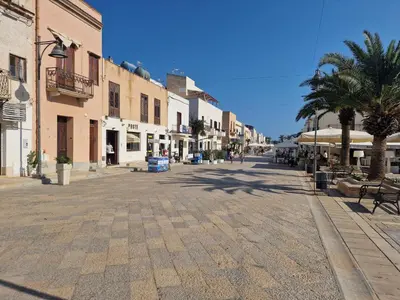 a street in a town with palm trees and buildings at Casa Sabrina in San Vito lo Capo