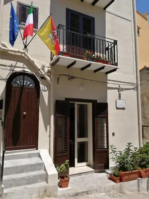 a building with two flags and a balcony at Opera Boutique Rooms in Monreale