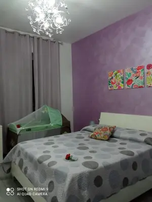 a bedroom with a bed and a green crib at Casa Le Rose in Palermo
