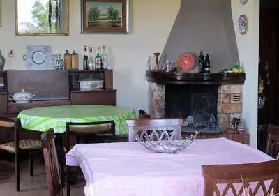 a dining room with two tables and a fireplace at Casa Vacanza nell'Orto in Termini Imerese