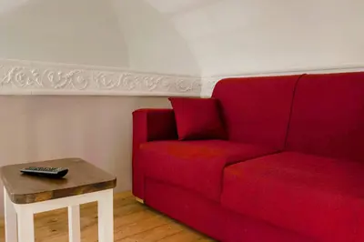 a living room with a red couch and a table at B&B Benincasa in Palermo