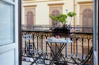 a balcony with a table and chairs on a balcony at B&B Benincasa in Palermo