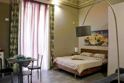 a bedroom with a bed and a table with a tableablish at B&B Benincasa in Palermo