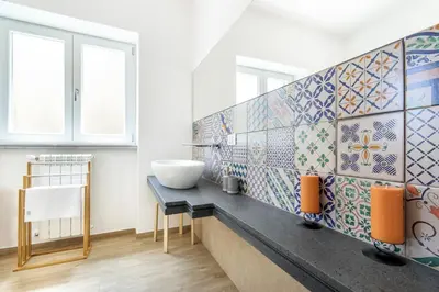 a bathroom with a sink and tiles on the wall at Teatro Massimo City Center Apartments in Palermo