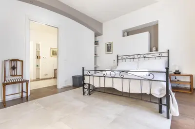 a bedroom with a bed with a mirror and a chair at Teatro Massimo City Center Apartments in Palermo