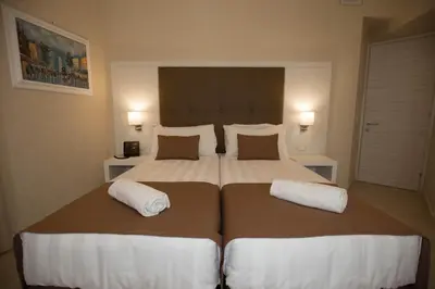 a bedroom with a large bed with two pillows at La Serenissima Hotel in Palermo