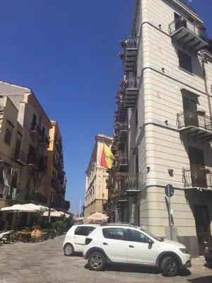 a white car parked in front of a building at La Serenissima Hotel in Palermo