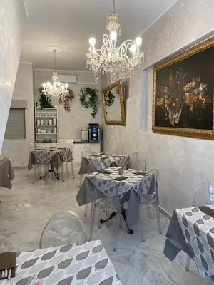 a dining room with tables and a painting on the wall at La Serenissima Hotel in Palermo