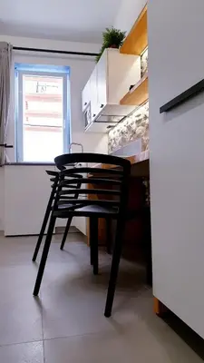 a black chair sitting at a table in a kitchen at Mediterraneo House in Palermo