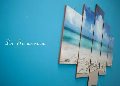 a row of pictures of the beach on a wall at La Trinacria in Terrasini
