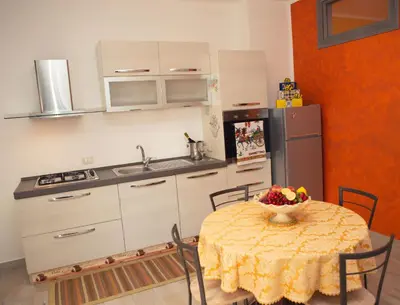 a kitchen with a table with a bowl of fruit on it at La Trinacria in Terrasini