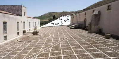 a stone courtyard with snow on the side of a building at Gibellina Home in Nuova Gibellina