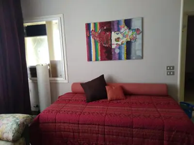 a bedroom with a bed with a red blanket at Gibellina Home in Nuova Gibellina