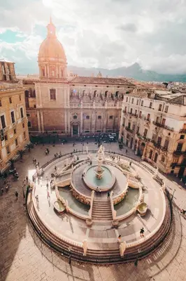 a large building with a fountain in a courtyard at B&B Villa Liberty sul Mare by Wonderful Italy in Palermo