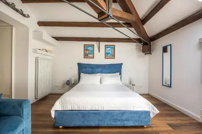 a bedroom with a blue bed and a blue chair at B&B Villa Liberty sul Mare by Wonderful Italy in Palermo