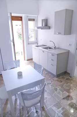 a kitchen with a table and chairs and a sink at Clambè in Palermo