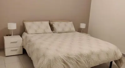 a bedroom with a bed and two lamps on tables at Appartamento a due passi dal mare in Palermo
