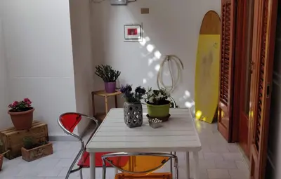 a white table with two chairs and flowers on it at Appartamento a due passi dal mare in Palermo