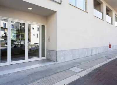 a tall apartment building with cars parked in front of it at I Mori Apartment in Palermo