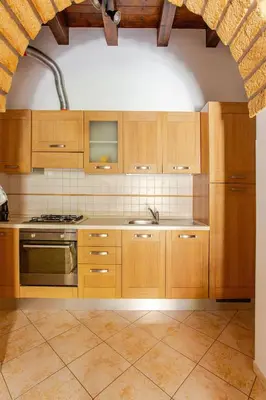 a kitchen with wooden cabinets and a stove top oven at Nino's house in Palermo