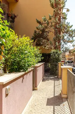 a courtyard with a fence and some plants and a tree at Nino's house in Palermo