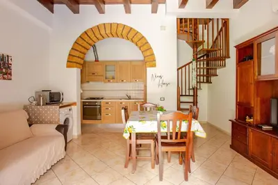 a kitchen and living room with a table and chairs at Nino's house in Palermo