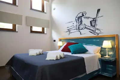 a bedroom with a large bed with a blue blanket at b&b Pirriera in Bagheria