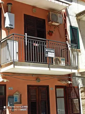 an orange building with a balcony and a sign on it at Sicilia Bedda isolotto in Isola delle Femmine