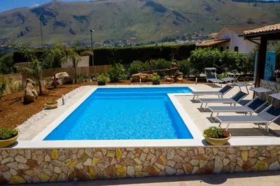 a swimming pool in a yard with lounge chairs at Villa Mirto in Castellammare del Golfo