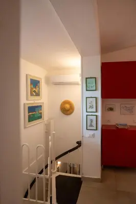 a staircase in a room with red cabinets at La casa del Rinoceronte - Scopello, con accesso diretto al mare in Castellammare del Golfo